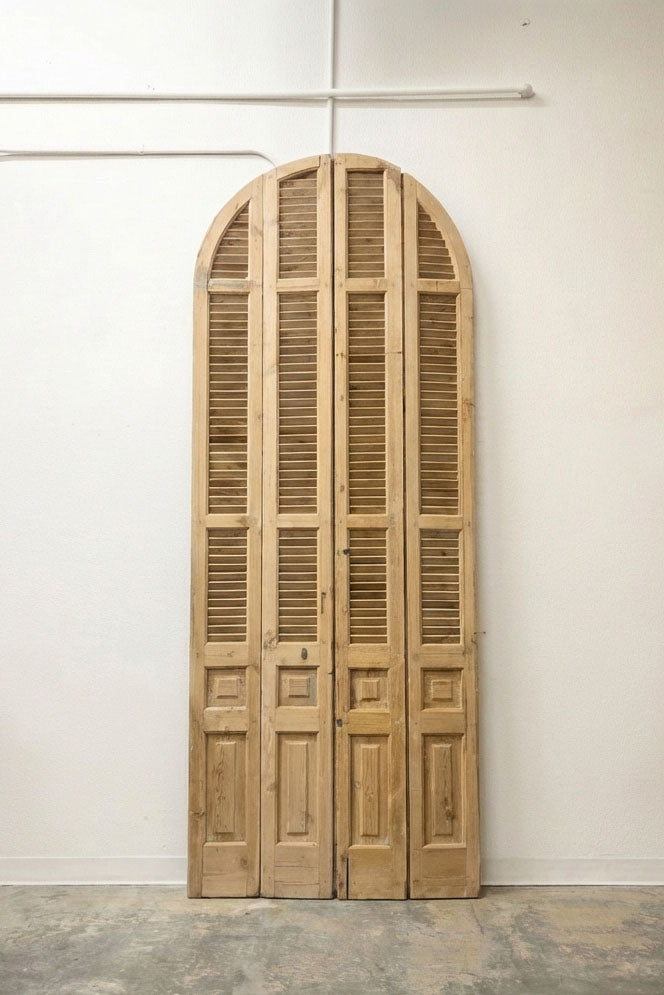 Grand arched louvered double doors in natural blonde pine, four-panel set
